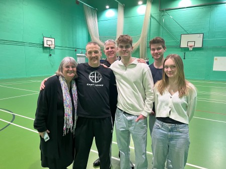 Jamie Perridge embraces Jack Taylor and his mum Andrea Cox. Jack's twin brother Max, Jack's girlfiend Lucy, and Jack's dad Rik join them for the picture. This photo was taken in the same sports hall Jack has his cardiac arrest in.