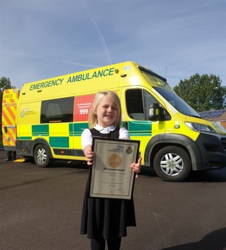 Emily award in front of ambulance.jpeg